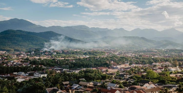 Lush mountain town with residential area and scenic mountain views, peaceful outdoor scenery.