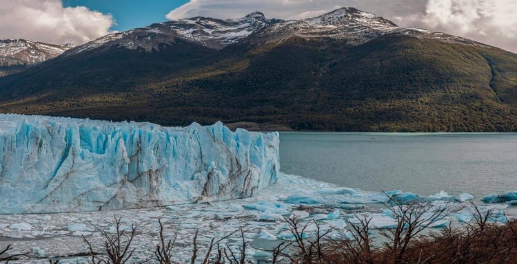 Majestic glacier in Patagonia with snow-capped mountains and icy waters.