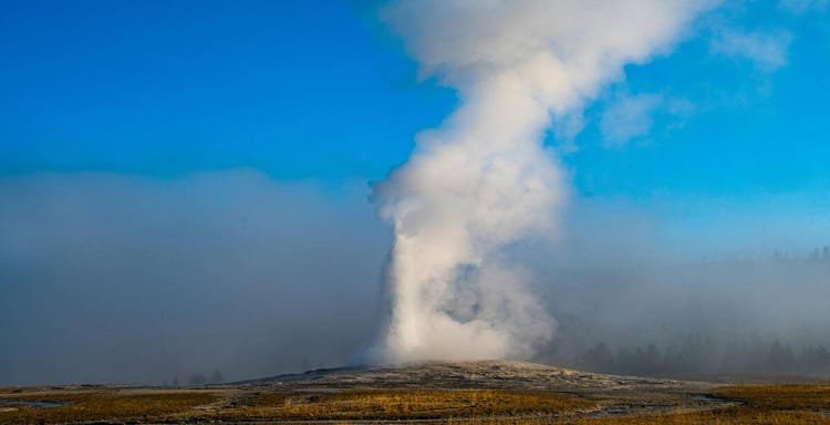 Steam erupting from geyser in national park, geothermal activity, natural hot spring, Yellowstone volcanic site, outdoor adventure.