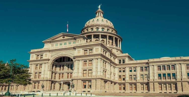 Historic Texas State Capitol building in Austin, Texas, with clear blue sky background.
