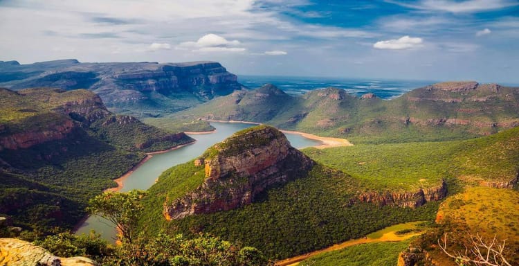 Vast canyon landscape with river and lush greenery, stunning scenic views in a national park.