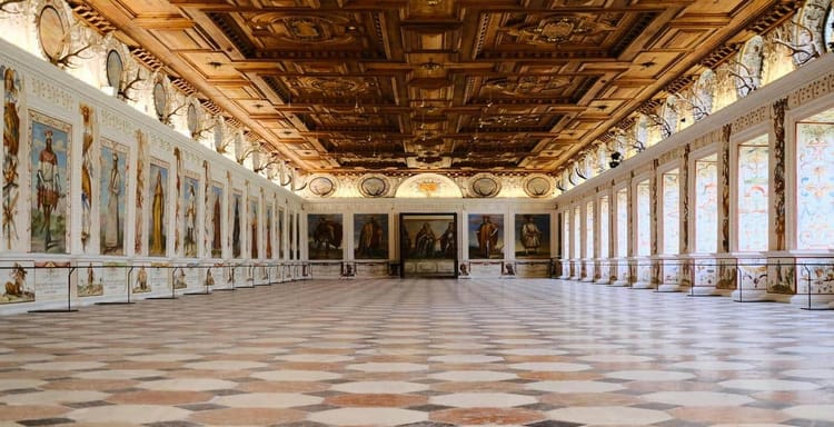 Vatican Museums grand hall with religious paintings and ornate wooden ceiling, iconic cultural destination.