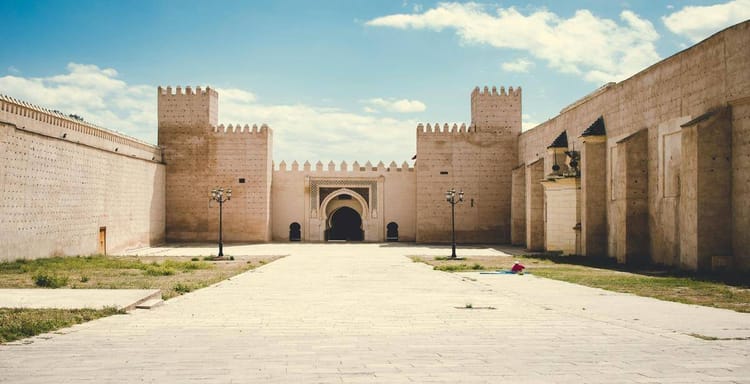 Ancient Moroccan fortress wall with large arched gateway, historic architecture and fortification design.