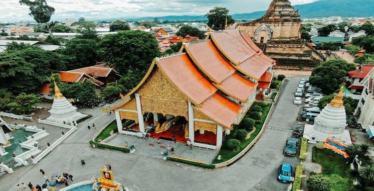 Colorful Thai temple with intricate architecture and lush surroundings in Thailand.