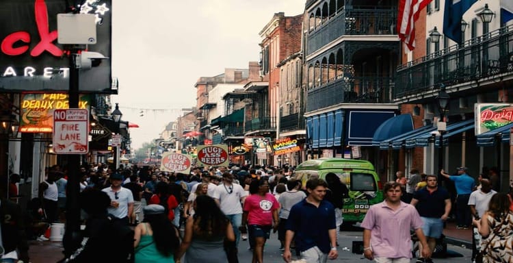 Crowded city street with nightlife, bars, and people enjoying nightlife activities.