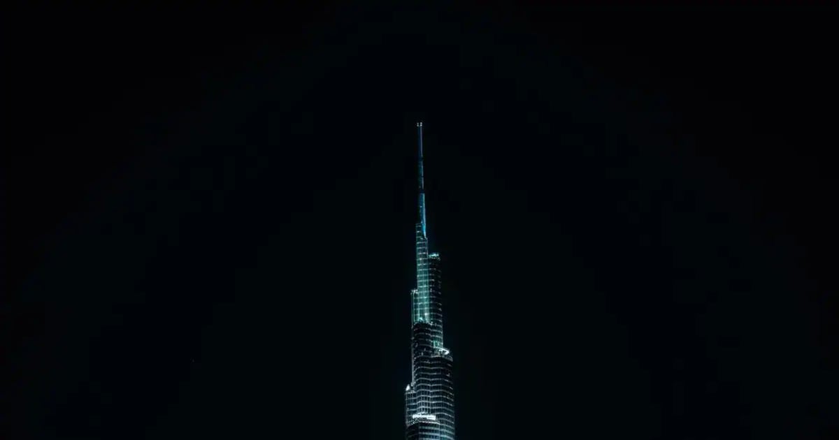 Brightly lit Dubai skyscraper at night, showcasing futuristic architecture and city skyline.