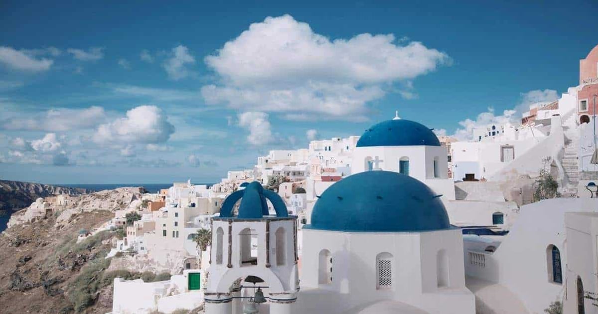 Vibrant Santorini village with iconic white buildings and blue domes, perfect for travel inspiration and scenic adventures.