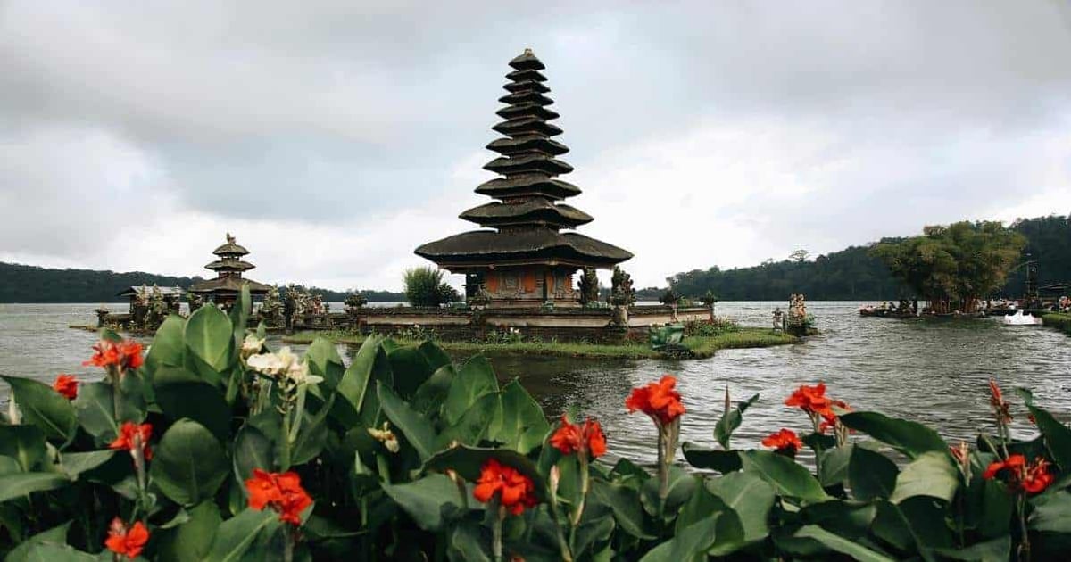 Ancient Hindu temple on Lake Beratan with lush greenery and scenic views in Bali, Indonesia.