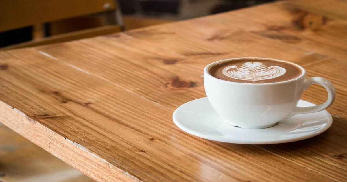 1. Coffee cup with latte art on wooden table, cozy coffee shop ambiance.