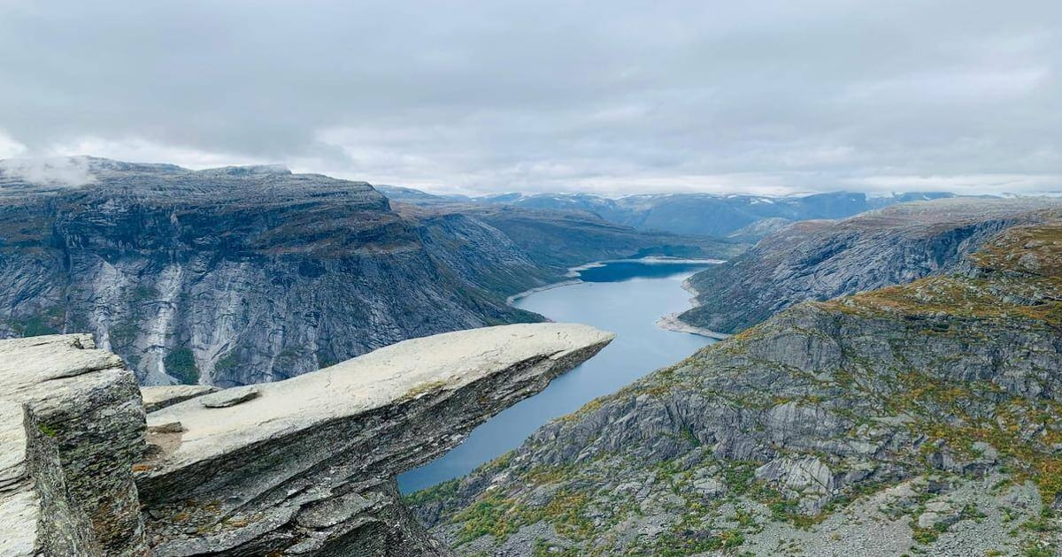Breathtaking mountain landscape over a fjord with dramatic cliffs and cloudy sky.