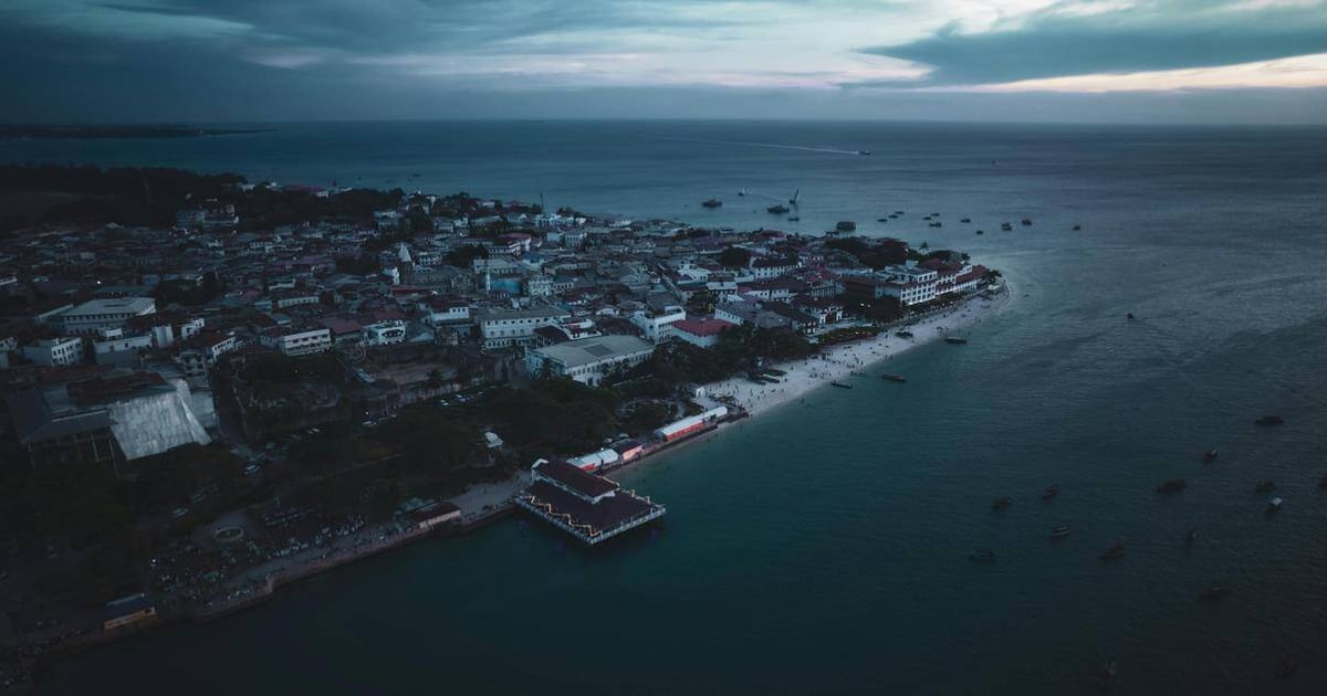 Aerial view of a coastal city with beach and harbor, highlighting travel and navigation in QuestForDirections.