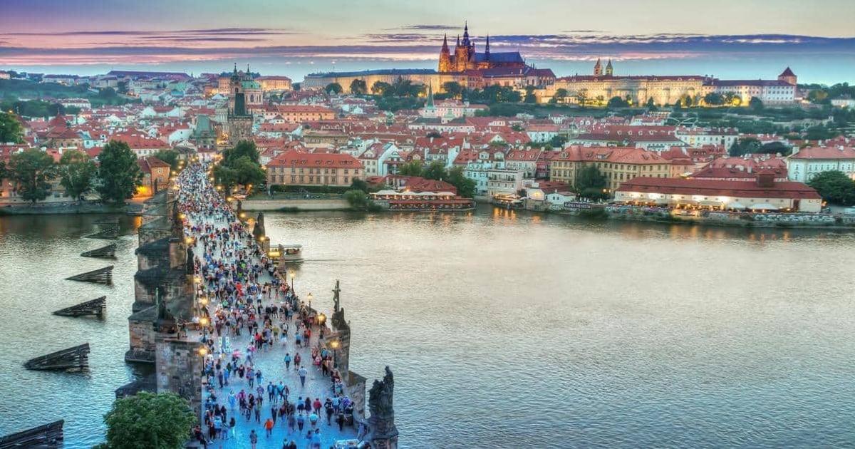 Historic Charles Bridge in Prague at dusk, showcasing Czech architecture and scenic views.