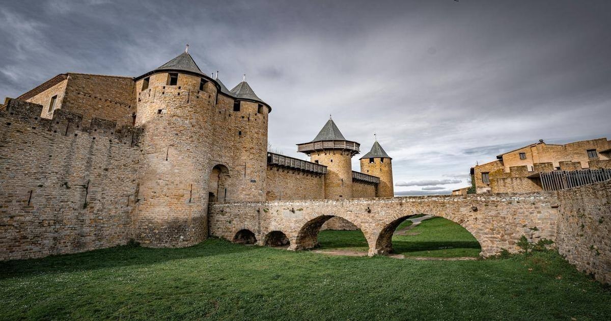 Medieval stone castle with round towers and stone bridge, historic fortress in rugged landscape, QuestForDirections.